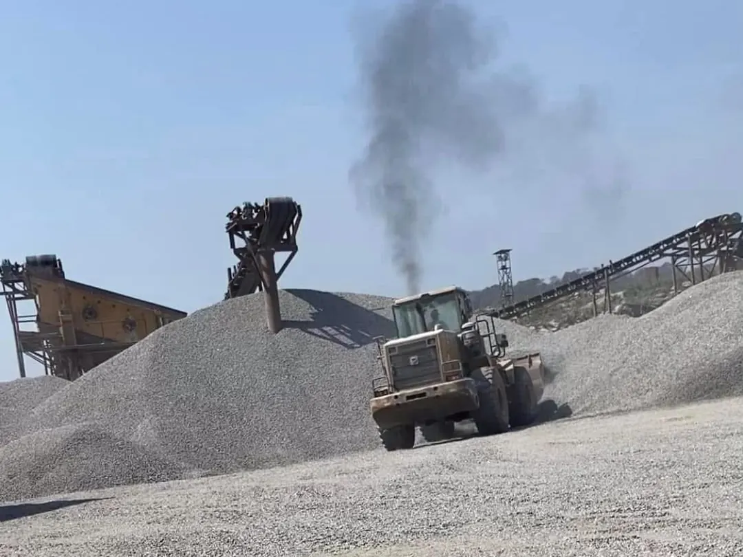 Chargeuse entre des tas de granite concassé dans une carrière